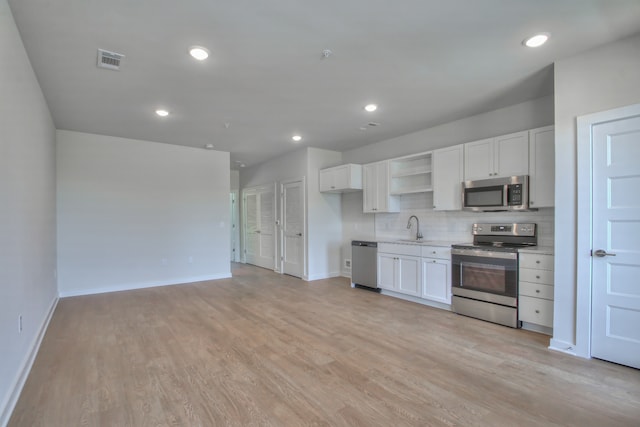 kitchen with white cabinets, appliances with stainless steel finishes, and light wood-type flooring