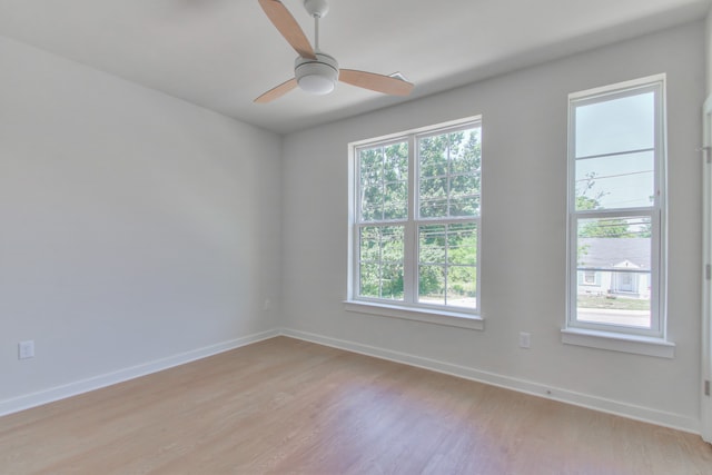 unfurnished room featuring ceiling fan, a wealth of natural light, and light wood-type flooring