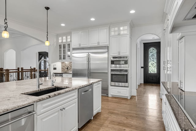 3609 Leipers Valley Trl, Franklin, TN 37064 - kitchen featuring light hardwood / wood-style floors, tasteful backsplash, appliances with stainless steel finishes, white cabinets, and hanging light fixtures