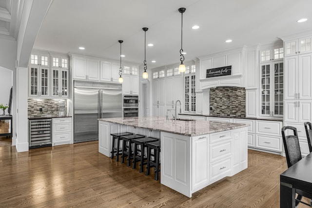 3609 Leipers Valley Trl, Franklin, TN 37064 - kitchen with backsplash, a center island with sink, stainless steel appliances, and hanging light fixtures