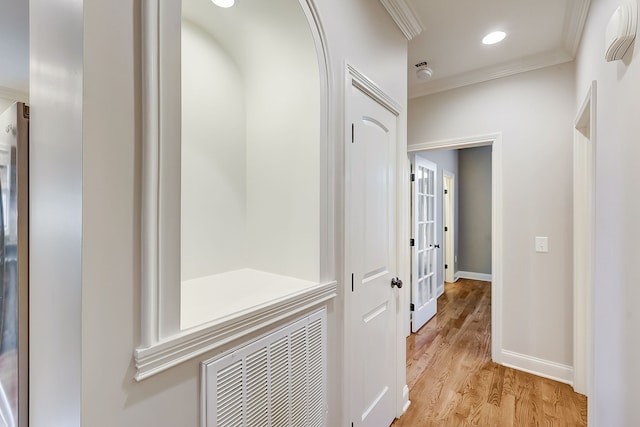 hall featuring ornamental molding and light hardwood / wood-style floors