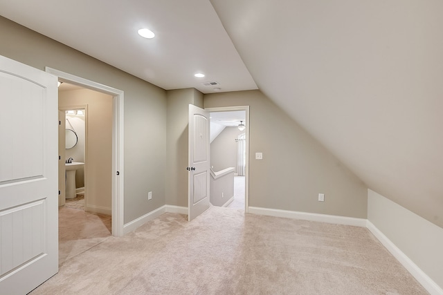 additional living space featuring light carpet and lofted ceiling