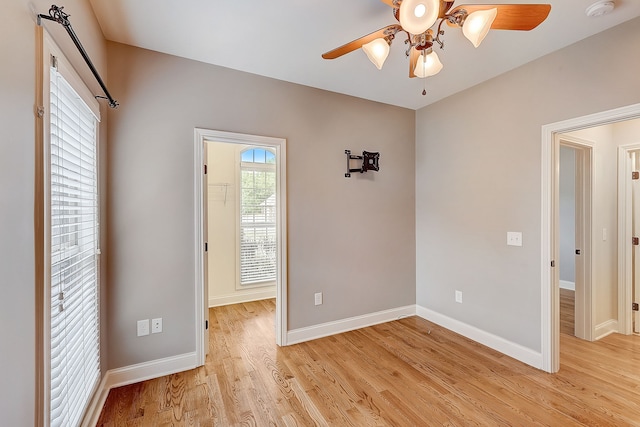 empty room with ceiling fan and light hardwood / wood-style flooring