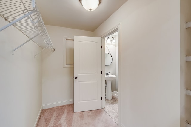 walk in closet featuring light carpet