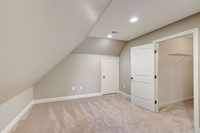 additional living space with light carpet and vaulted ceiling