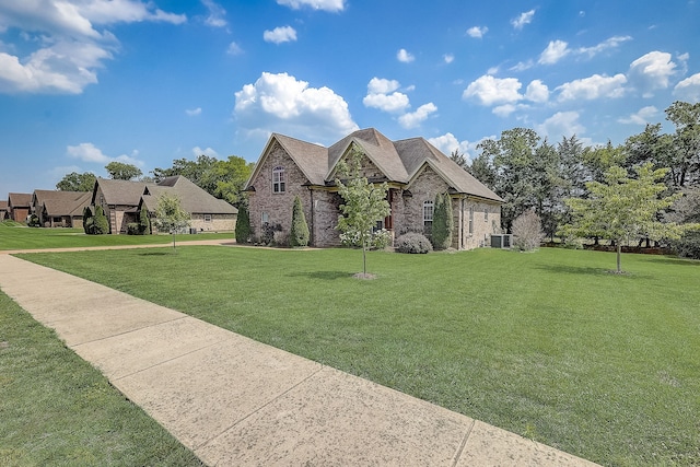 view of front of house featuring central AC and a front lawn