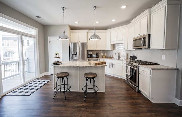 kitchen with backsplash, appliances with stainless steel finishes, and dark hardwood / wood-style flooring