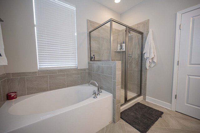 bathroom with tile flooring and separate shower and tub