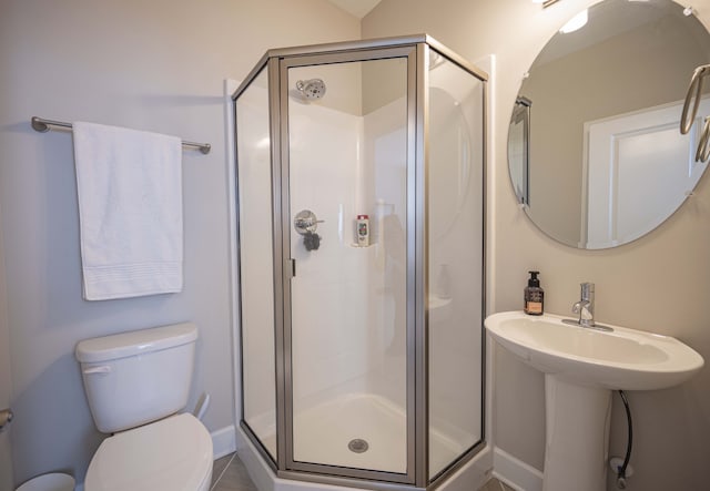 bathroom featuring toilet, tile flooring, and an enclosed shower