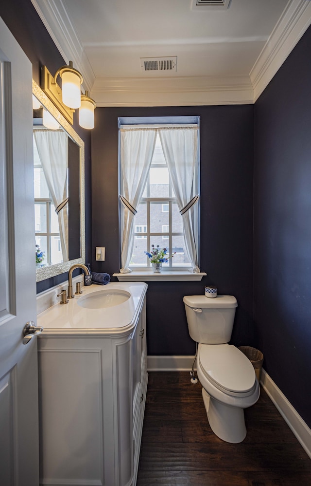 bathroom with hardwood / wood-style flooring, toilet, vanity, and crown molding