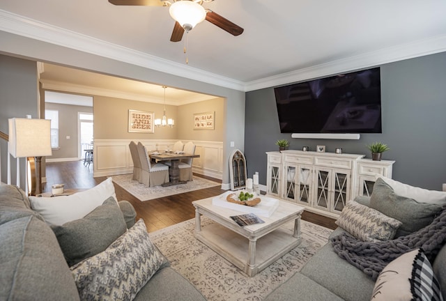 living room featuring crown molding, ceiling fan with notable chandelier, and hardwood / wood-style flooring