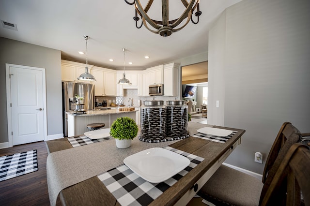 dining space with dark hardwood / wood-style flooring and a chandelier