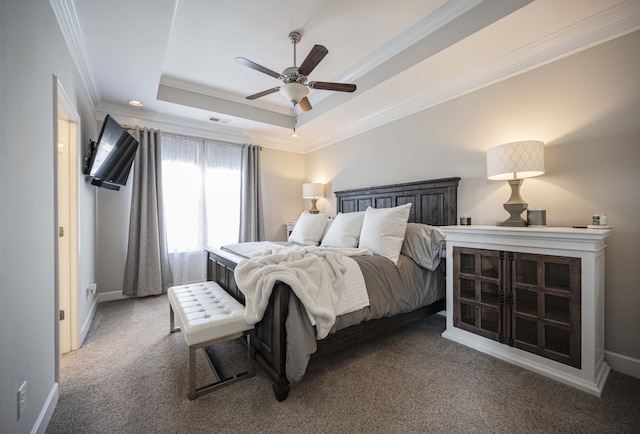 carpeted bedroom with ceiling fan, crown molding, and a tray ceiling