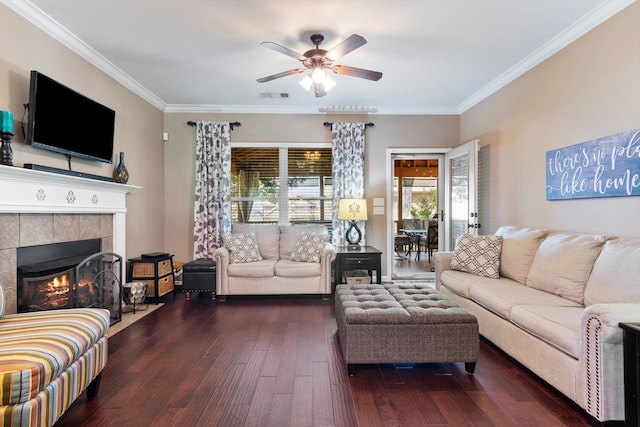 living room with crown molding, dark hardwood / wood-style floors, a fireplace, and ceiling fan