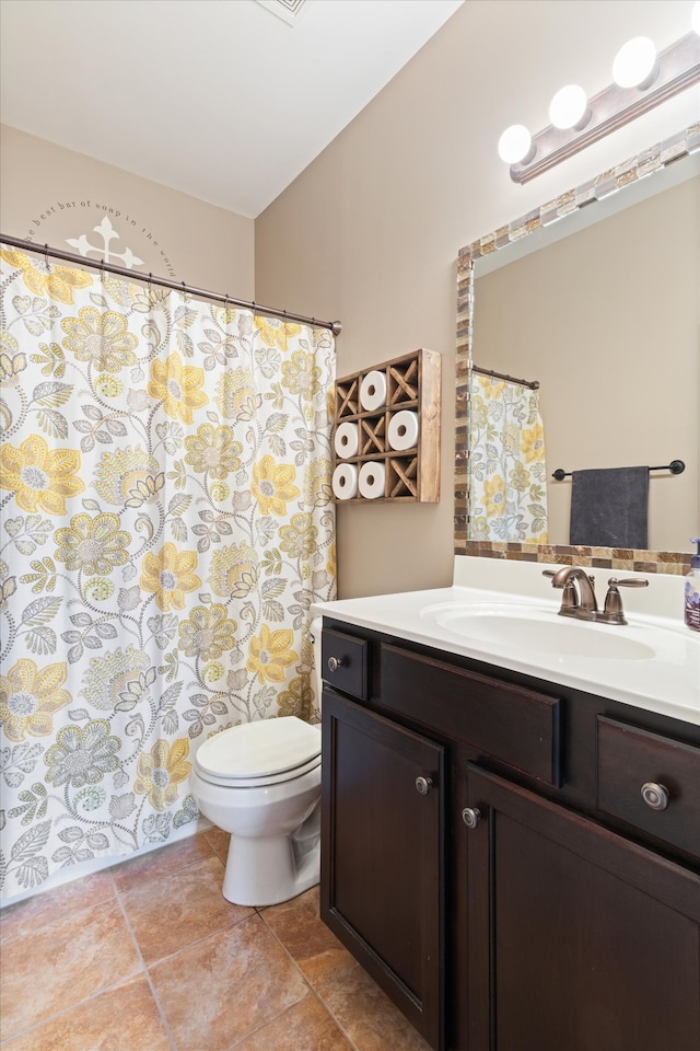 bathroom featuring tile floors, toilet, and vanity