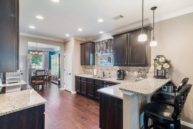 kitchen featuring decorative light fixtures, dark hardwood / wood-style flooring, a chandelier, light stone countertops, and backsplash