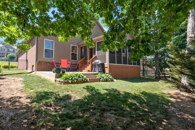 back of house featuring a patio, a sunroom, and a yard