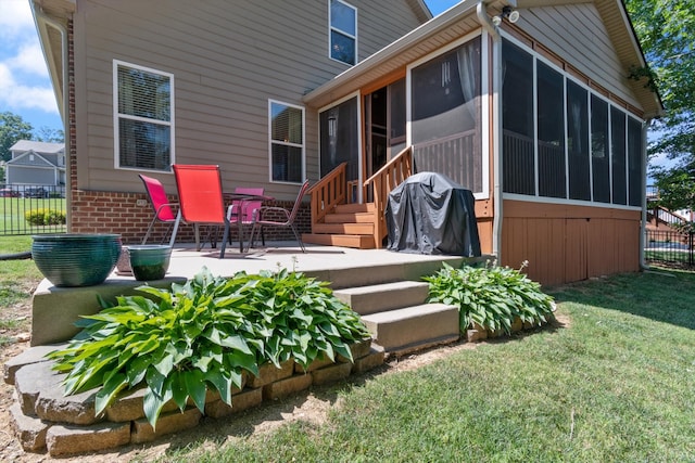 back of house featuring a sunroom, a lawn, and a patio