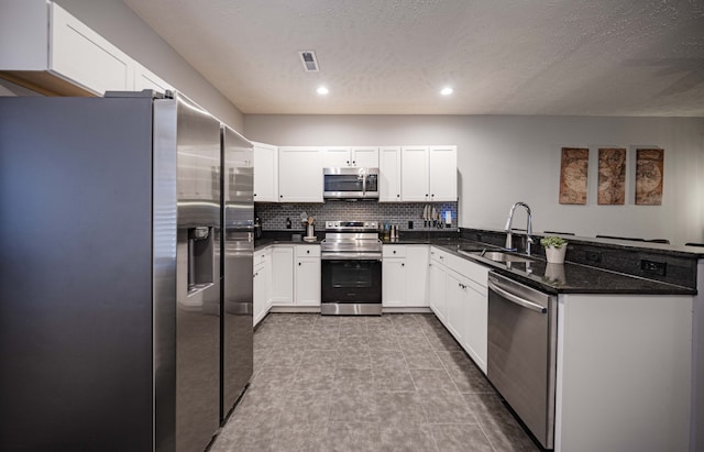 kitchen with sink, white cabinets, stainless steel appliances, light tile flooring, and tasteful backsplash