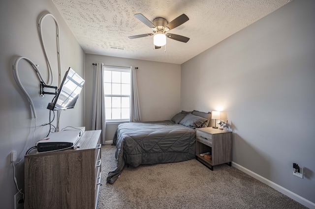 carpeted bedroom featuring ceiling fan and a textured ceiling