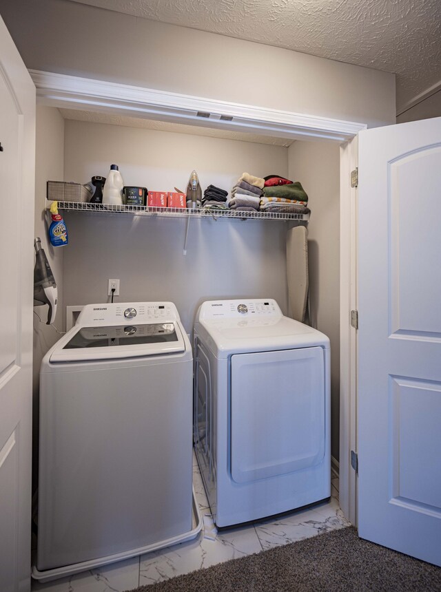 laundry room with light tile floors, a textured ceiling, and separate washer and dryer