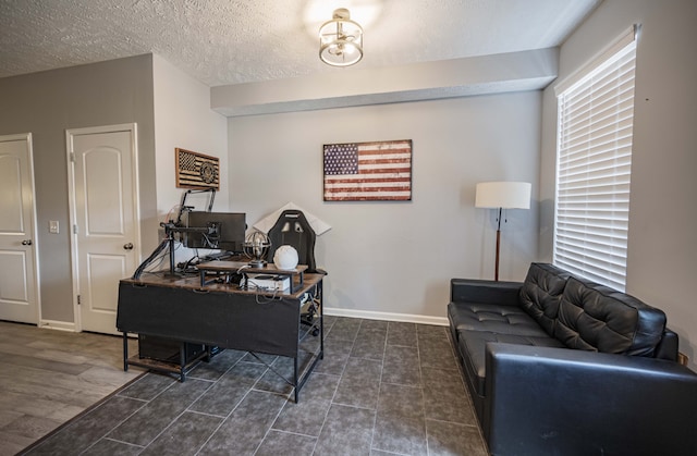 office featuring a textured ceiling, a healthy amount of sunlight, and dark hardwood / wood-style flooring