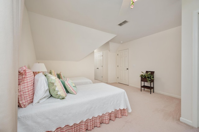 bedroom with lofted ceiling and light colored carpet