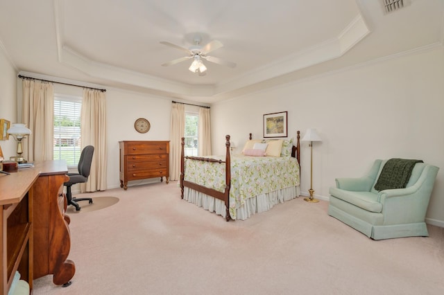 bedroom with ceiling fan, ornamental molding, a tray ceiling, and light carpet