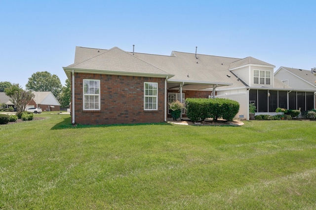 rear view of property with a lawn and a sunroom