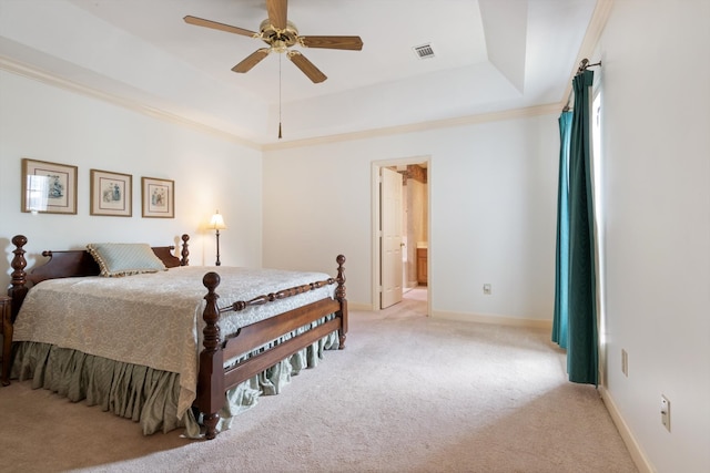 bedroom with light colored carpet, ceiling fan, connected bathroom, ornamental molding, and a raised ceiling