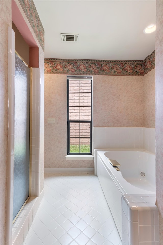 bathroom featuring shower with separate bathtub and tile floors