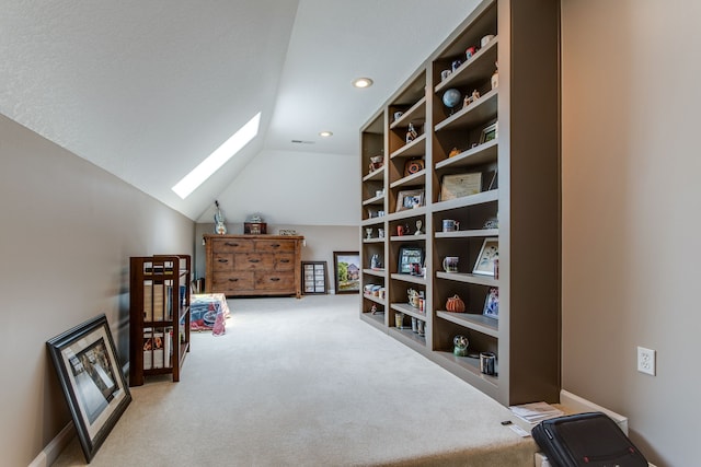 interior space with lofted ceiling with skylight and light carpet