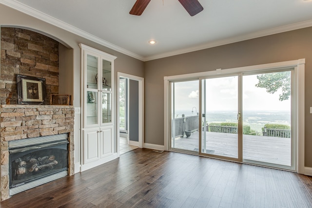 entryway with crown molding, a fireplace, ceiling fan, and dark hardwood / wood-style flooring