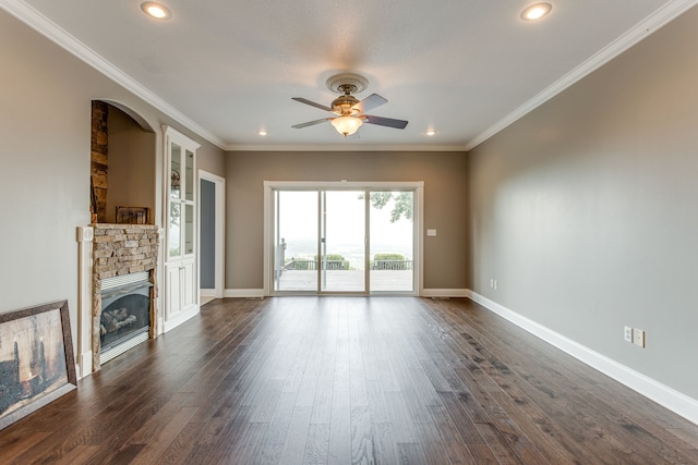 unfurnished living room with crown molding, a stone fireplace, ceiling fan, and dark hardwood / wood-style flooring