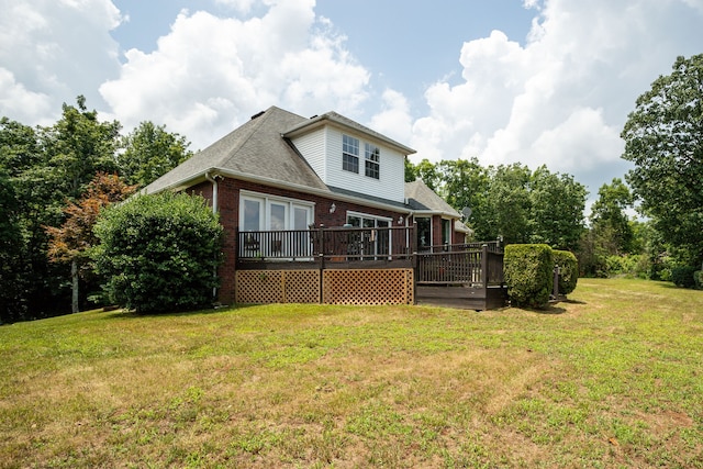 rear view of property featuring a lawn and a wooden deck