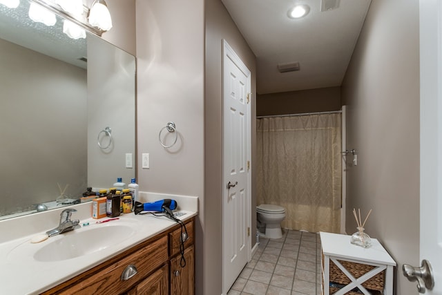 bathroom featuring toilet, vanity with extensive cabinet space, and tile flooring