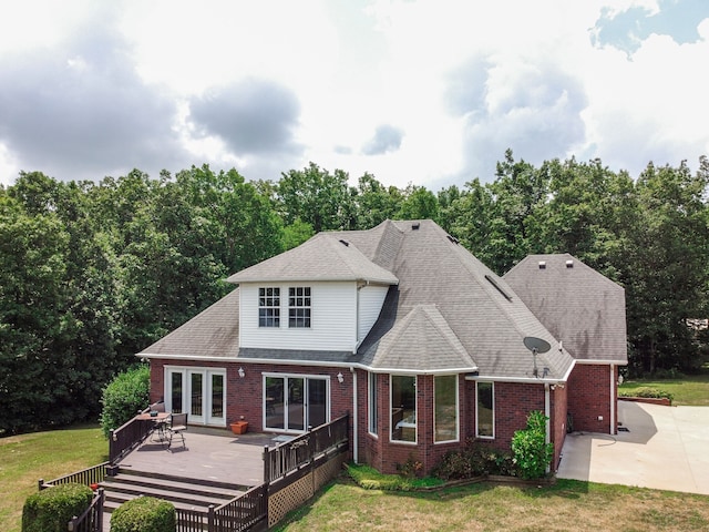 back of property featuring a wooden deck and a lawn