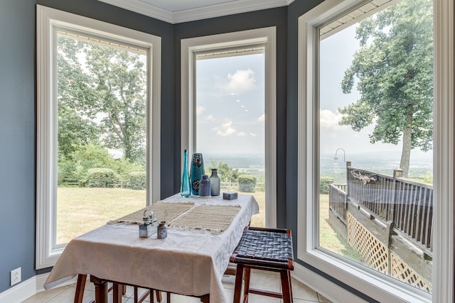 dining room with plenty of natural light, ornamental molding, and light tile floors