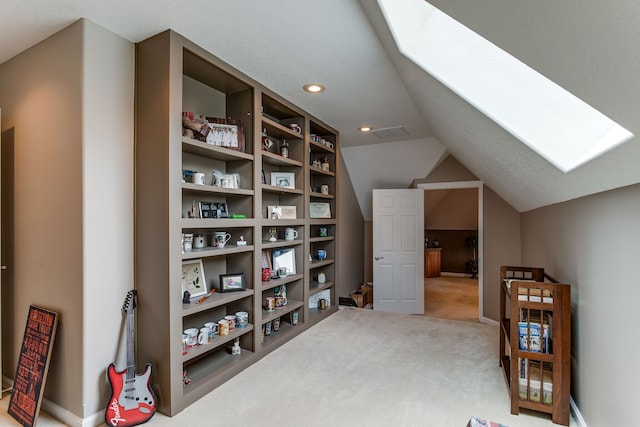 walk in closet featuring light carpet and lofted ceiling with skylight