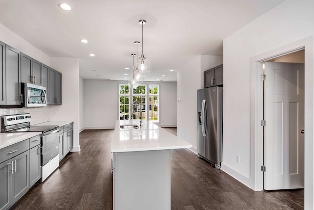 kitchen featuring a kitchen island, gray cabinets, dark hardwood / wood-style flooring, and stainless steel appliances