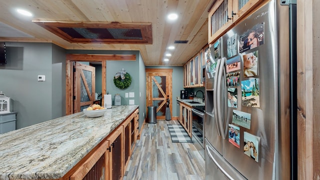 interior space featuring light hardwood / wood-style floors, wood ceiling, and sink