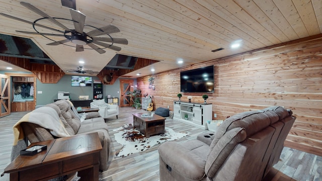 living room with wooden walls, wood ceiling, light hardwood / wood-style floors, and ceiling fan