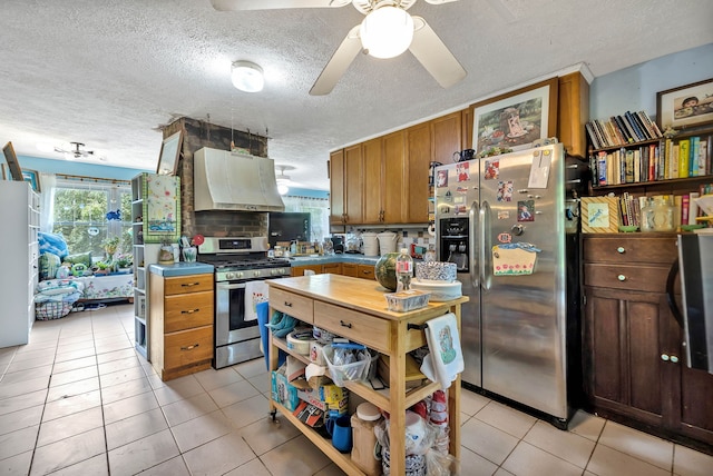 kitchen with premium range hood, ceiling fan, stainless steel appliances, a textured ceiling, and light tile patterned floors