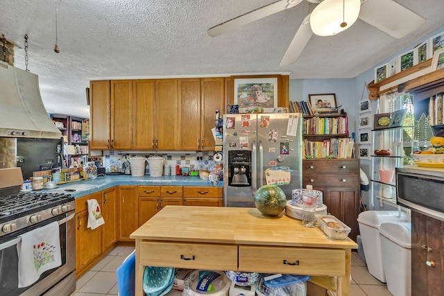 kitchen with premium range hood, appliances with stainless steel finishes, light tile patterned floors, and ceiling fan