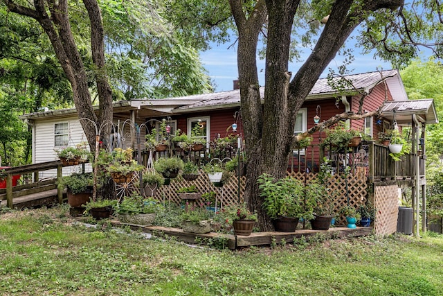 view of front of property with central AC, a front lawn, and a wooden deck