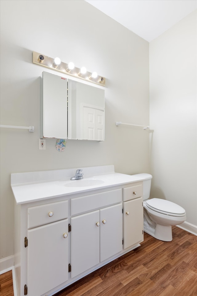 bathroom with hardwood / wood-style floors, vanity, and toilet