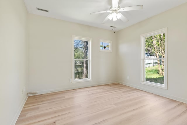 empty room with ceiling fan and light hardwood / wood-style flooring