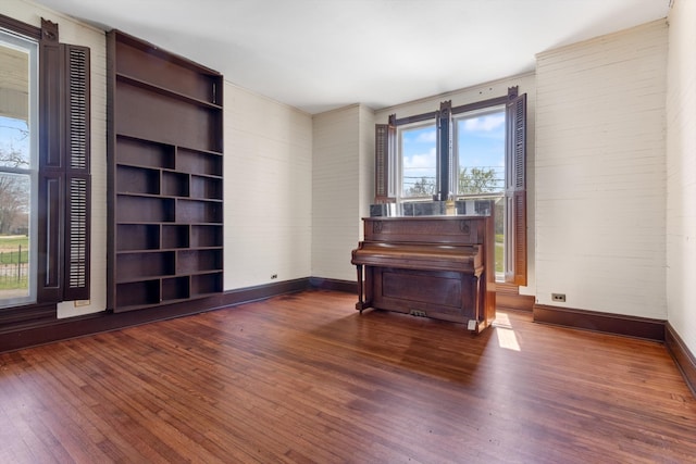 miscellaneous room featuring built in features and dark wood-type flooring