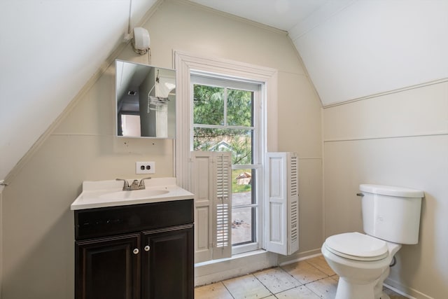 bathroom featuring vanity, toilet, and lofted ceiling