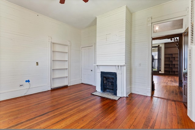 unfurnished living room featuring ceiling fan, dark hardwood / wood-style flooring, and built in features